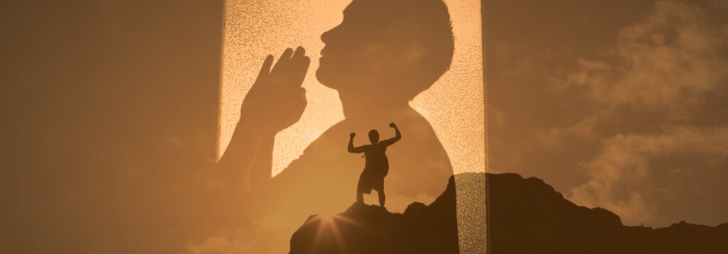 Man sieht den Schatten eines betenden Menschen über dem Bild eines Menschen, der auf einem Berg steht und die Arme siegreich nach oben hält. Die Sonne sheint direkt hinter ihm. 